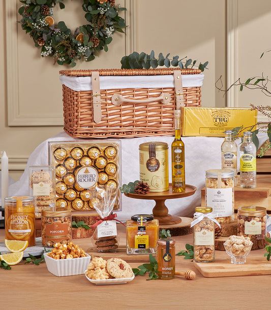 Golden gourmet gift basket with chocolates, honey, tea, and treats for New Year celebration
