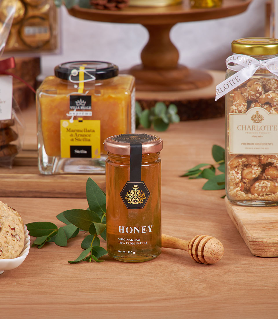 Golden gourmet breakfast basket with honey, marmalade, and sesame nuts for New Year gifting
