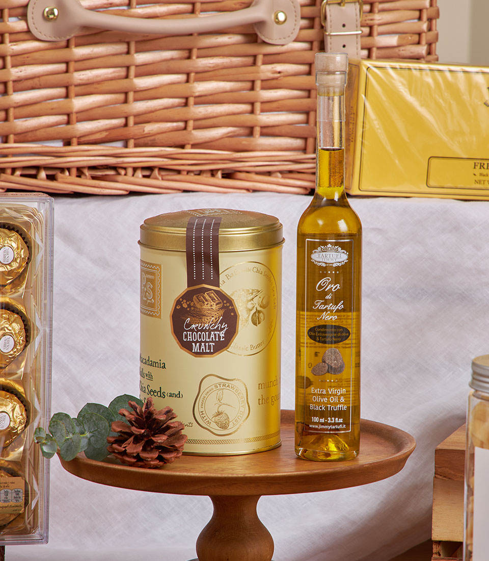 Golden gourmet breakfast basket with chocolates, truffle oil, chocolate malt tin, and picnic essentials for New Year