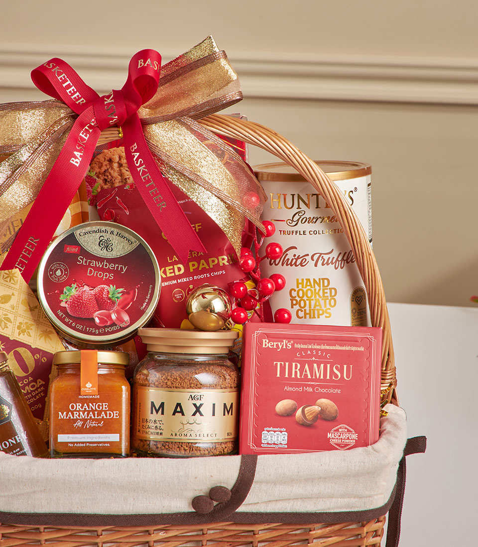 Woven wicker gourmet hamper with Walkers truffle chips, chocolate, coffee and preserves, red ribbon and gold accents for New