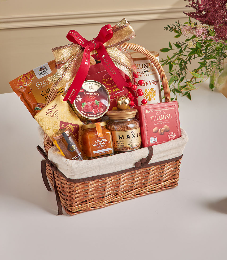 Woven wicker gourmet hamper with Walkers chips, truffles, chocolate and artisan treats tied with gold ribbon, New Year gift