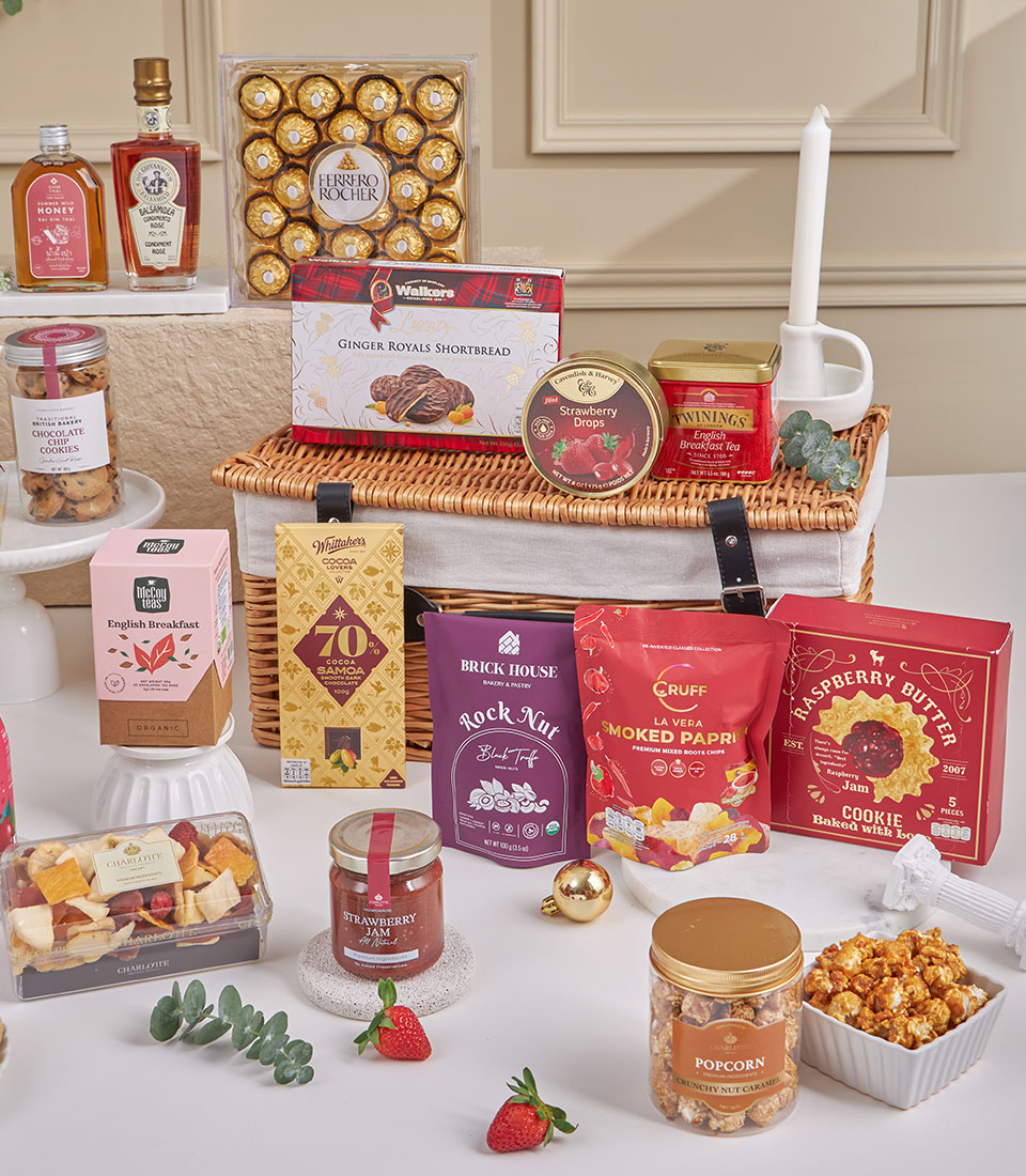 Premium gourmet gift hamper with chocolates, tea, cookies, honey, and artisan treats in wicker basket for New Year