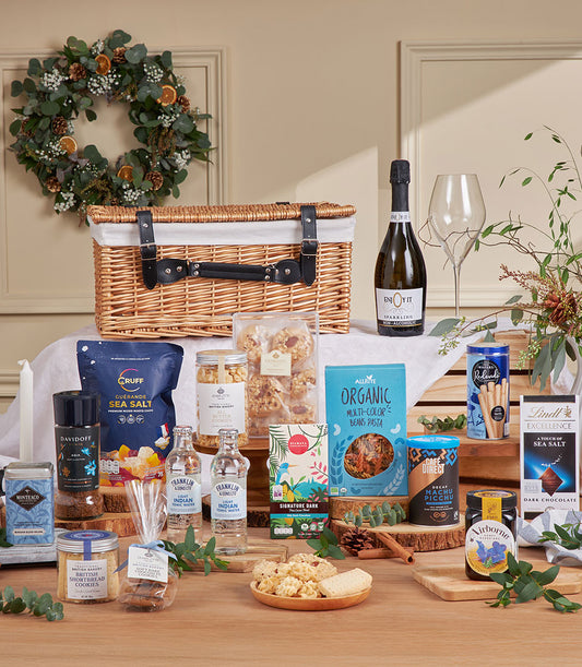 Luxury wicker gift basket filled with gourmet treats, sparkling beverages, and artisan foods for New Year celebrations