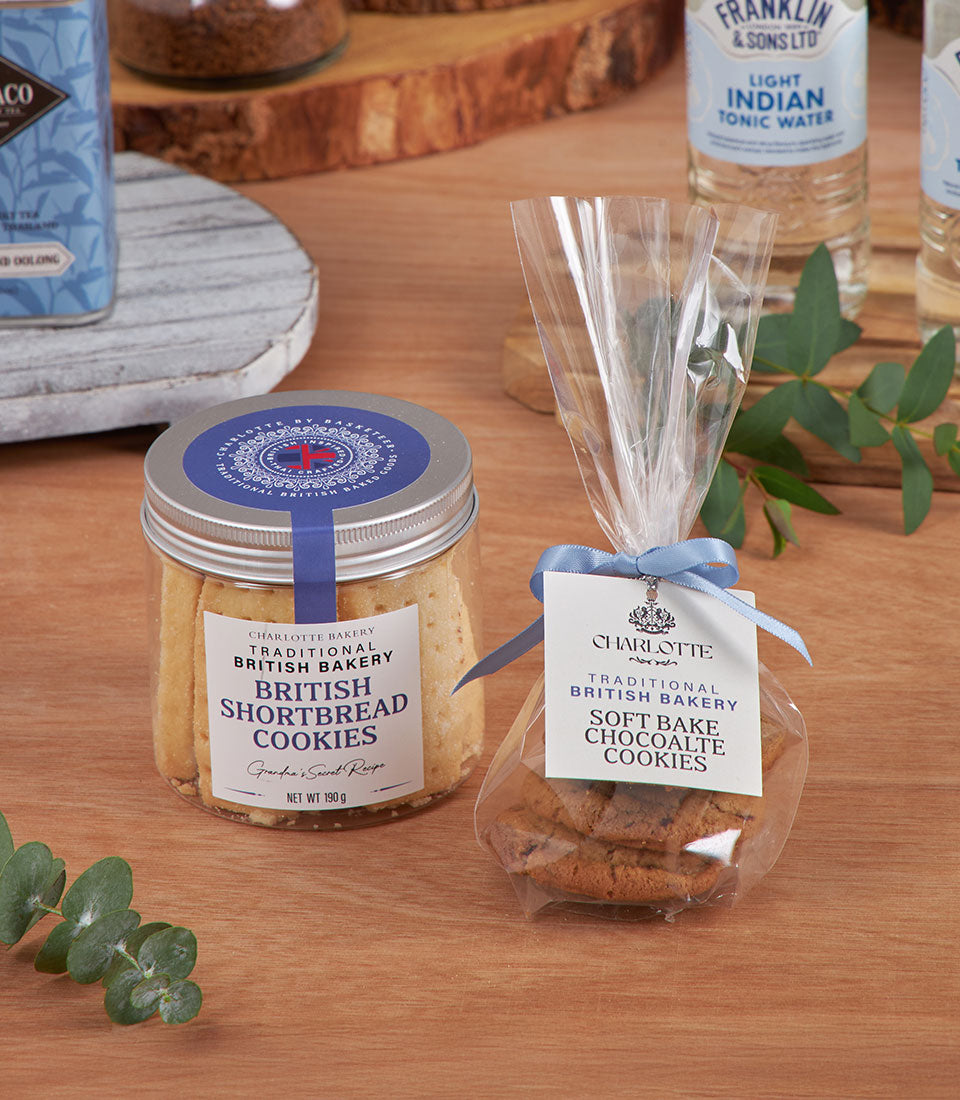Luxury New Year gift basket with British shortbread cookies, chocolate bakes, and sparkling tonic water in blue and gold