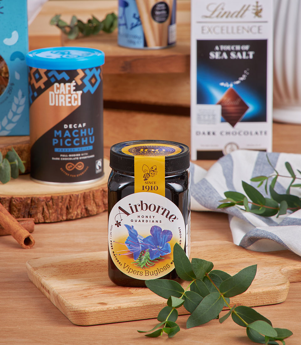 Blue and gold luxury gift basket with Manuka honey, specialty coffee, and dark chocolate for New Year