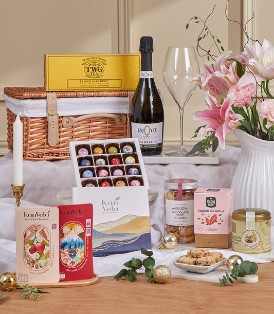 Luxury champagne-style chocolate gift box with gourmet treats, tea, and sparkling beverage for New Year celebrations