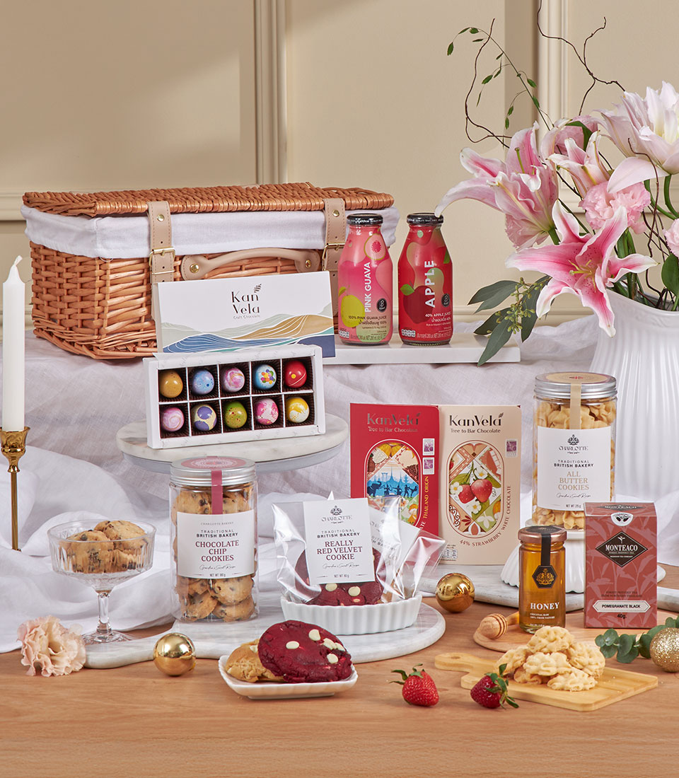 Luxury pink guava and chocolate tea gift hamper with wicker basket, gourmet cookies, artisan chocolates, and fresh florals