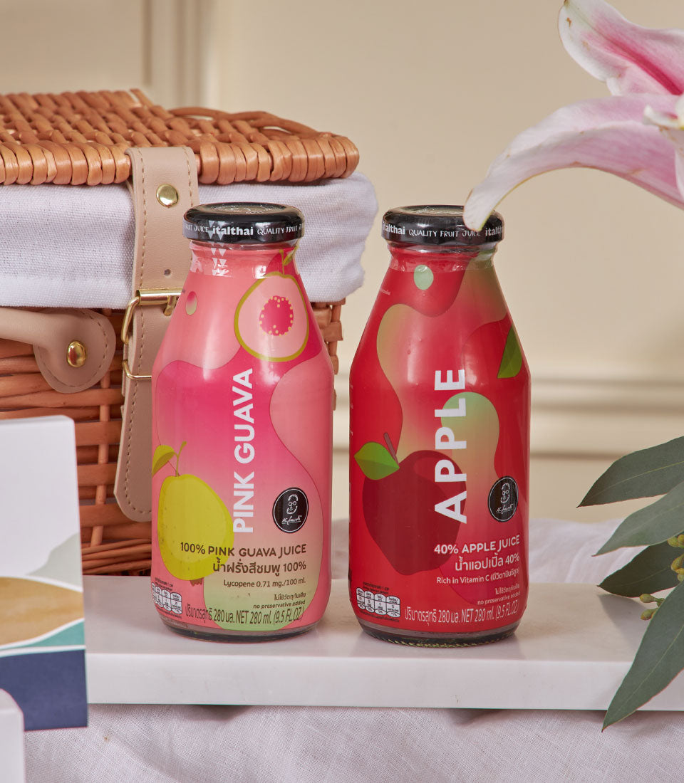 Pink guava and apple juice gift hamper in wicker basket, New Year gourmet gift set