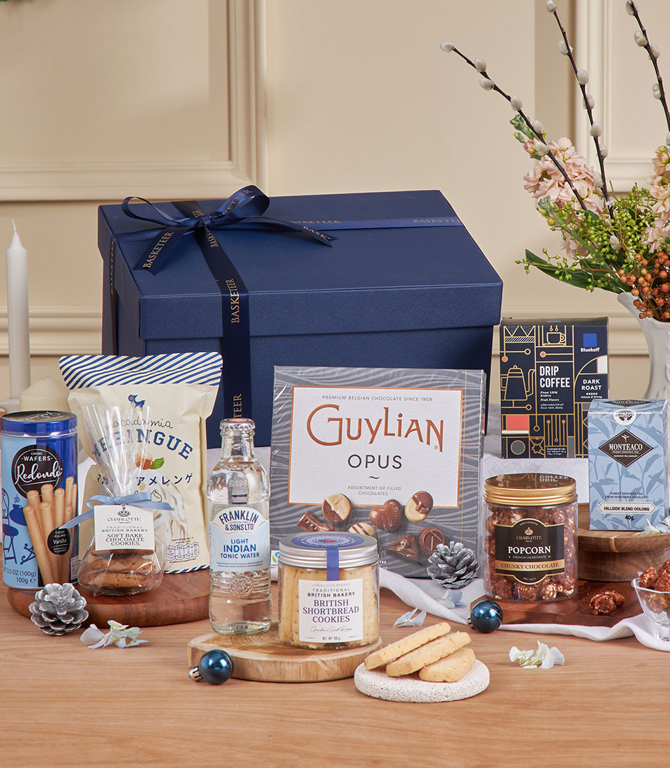 Luxury navy gift box with gourmet chocolates, shortbread, coffee, and gourmet treats for New Year celebrations