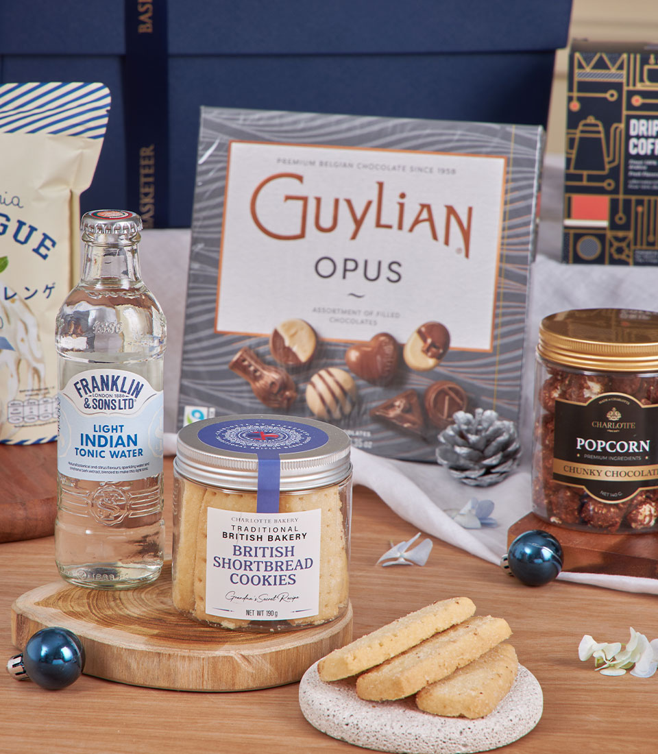Luxury gourmet gift basket with chocolates, shortbread, popcorn, and premium tonic water for New Year celebrations
