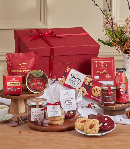 Red velvet gourmet gift basket with chocolate, cookies, tea, jam, and festive treats for New Year gifting