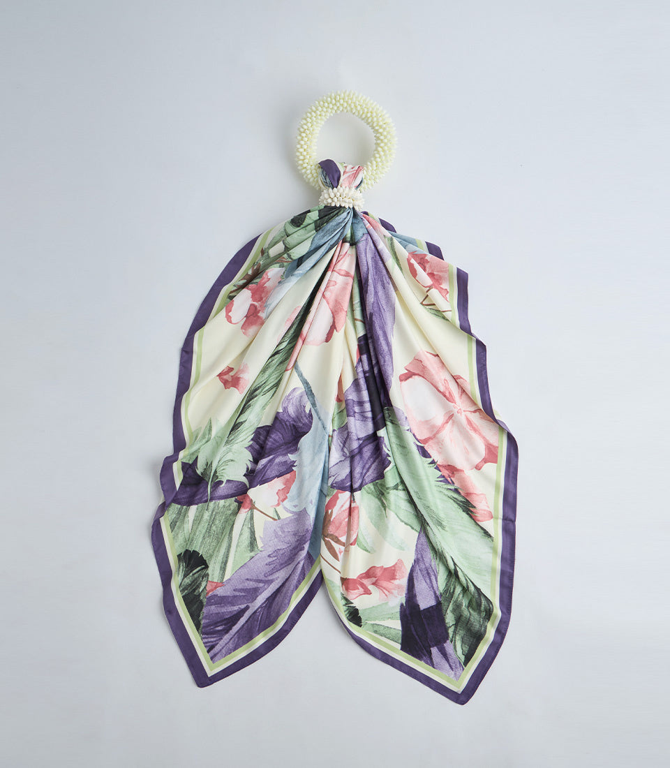 Floral silk scarf with cream, purple, pink and green colors, featuring roses and botanical prints, attached to a cream beaded ring handle.