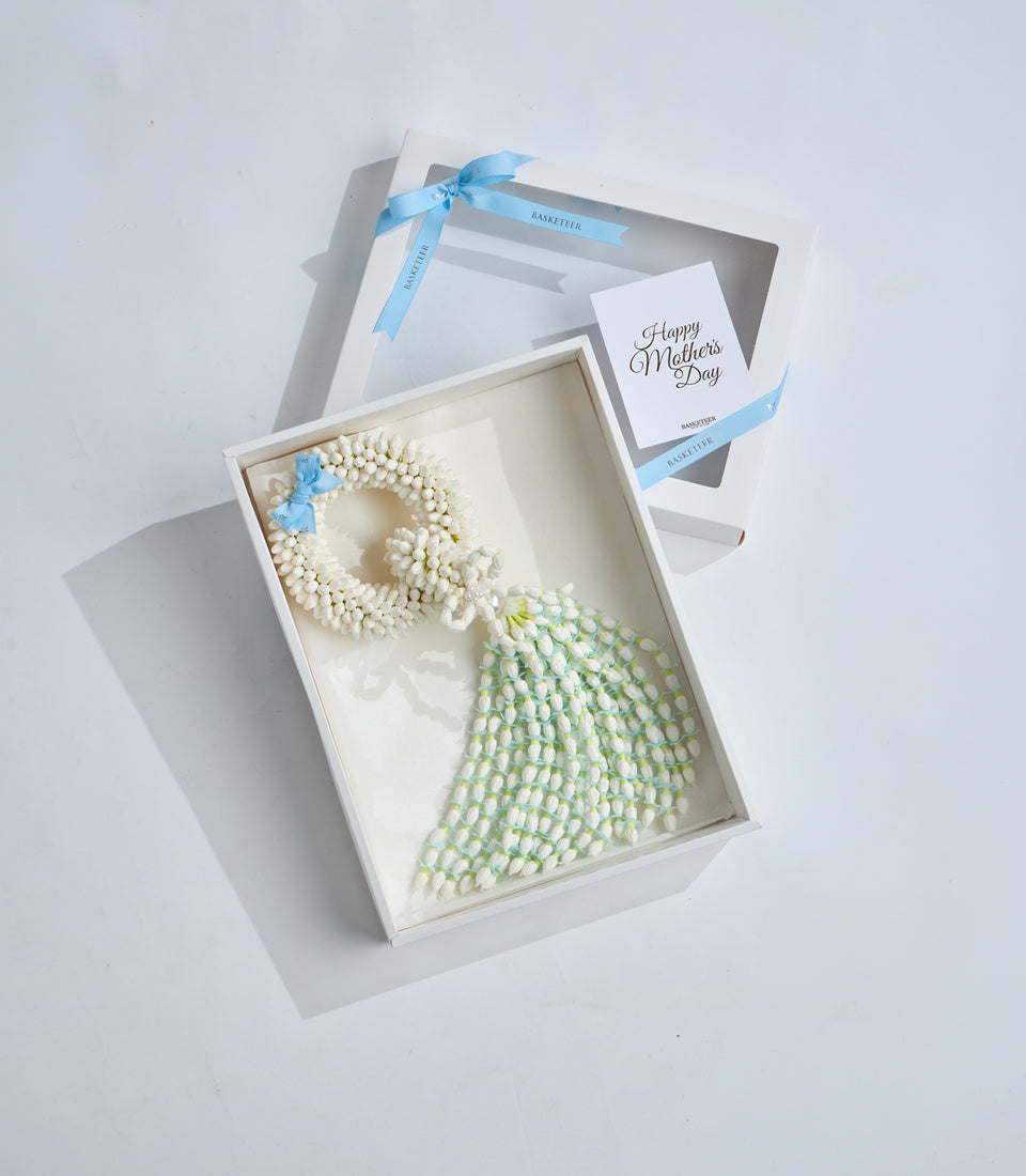 Elegant Mother's Day gift set featuring a cream pearl beaded wreath with blue accents and green beaded tassel in white box with blue ribbon.