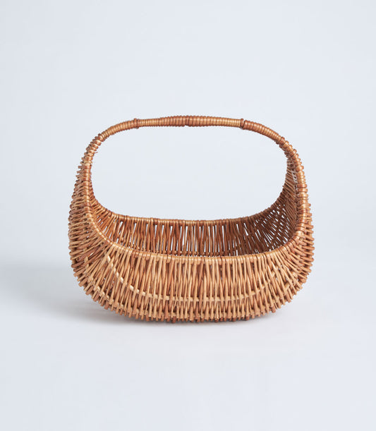 Handwoven light brown wicker basket with arched handle, ready for gourmet gifts