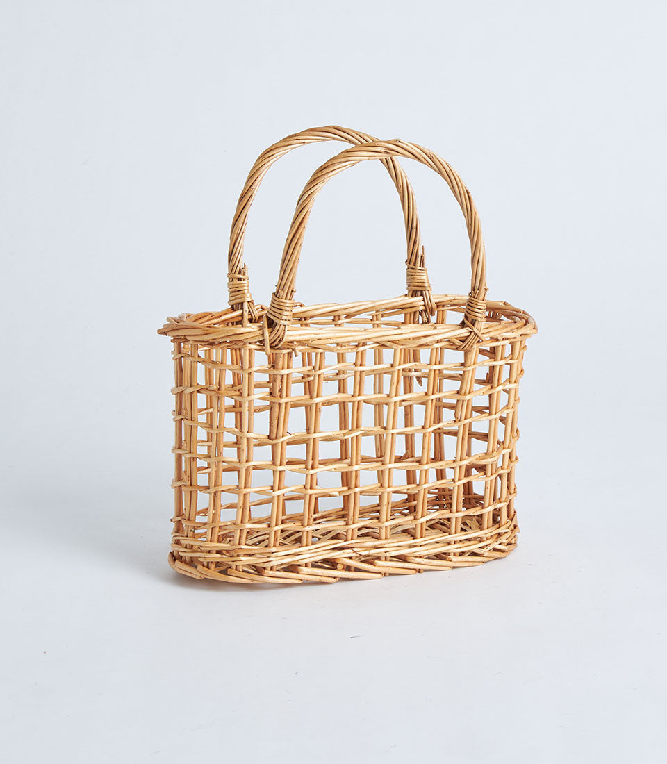 Light brown wicker basket with arched handles, open weave design for gift hampers and curated gifting