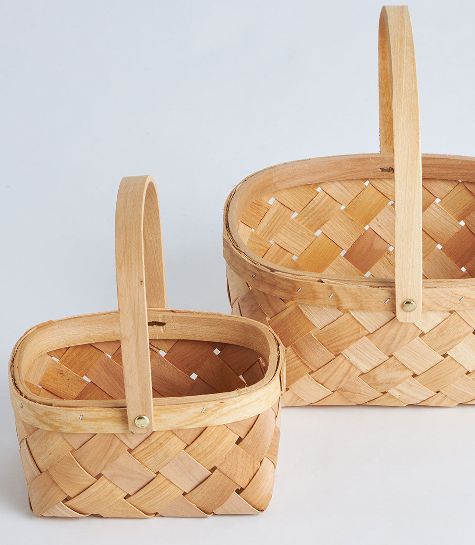 Light natural woven bamboo oval basket with arched handle, handcrafted for premium gift hampers