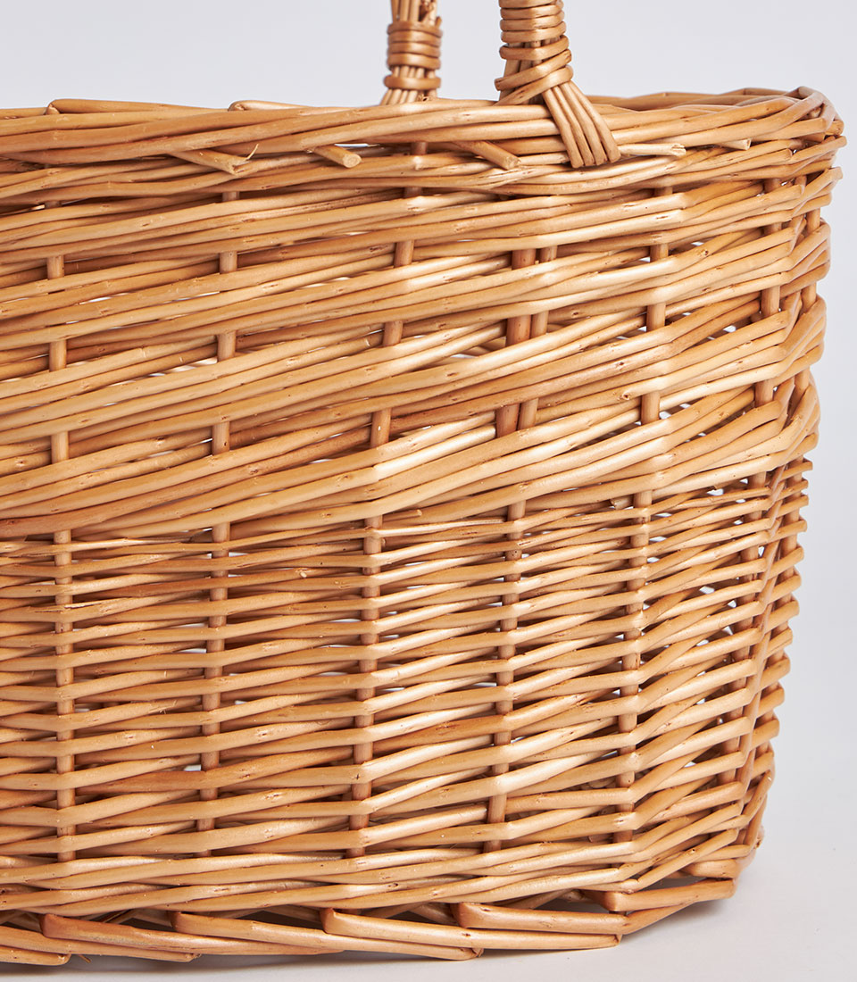 Handwoven oval wicker basket with natural willow texture and dual handles