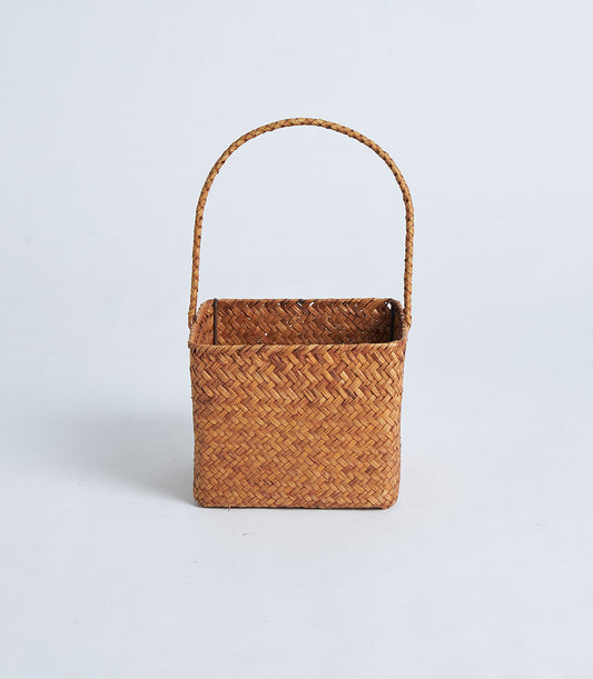 Natural brown woven rattan basket with braided handle for gifting and storage