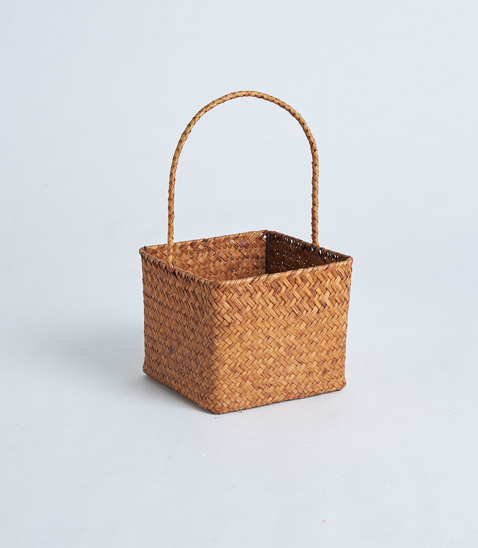 Natural brown woven square basket with curved handle, ready for gift filling