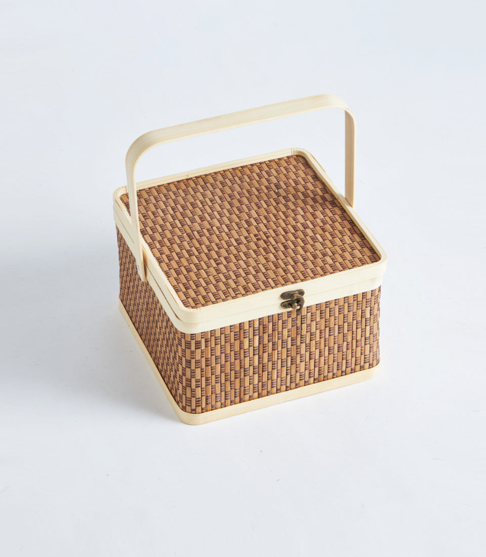 Woven rattan picnic basket with wooden trim and brass latch, natural brown tones