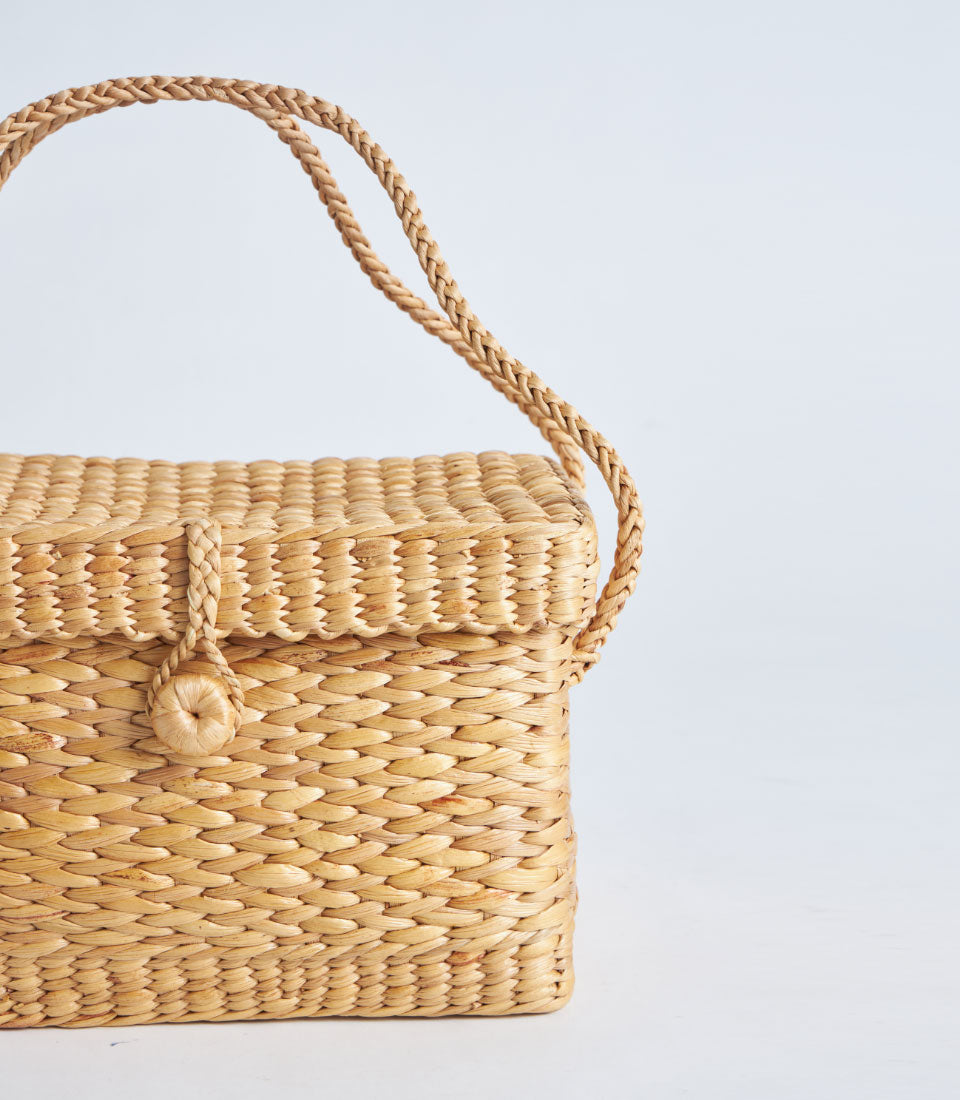 Natural woven straw basket with fitted lid and braided handle, light golden-brown artisan gift hamper
