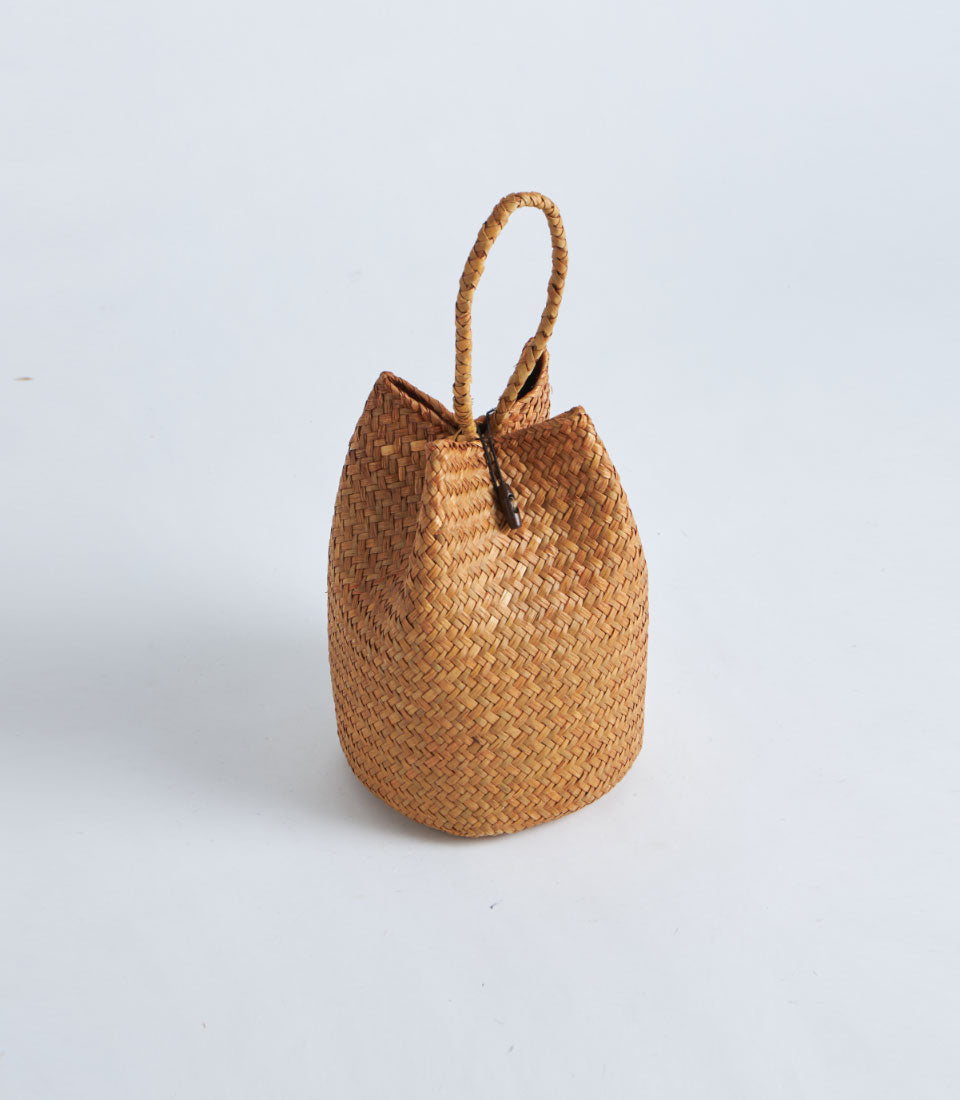 Natural straw gift basket with rope handle and red tassel detail
