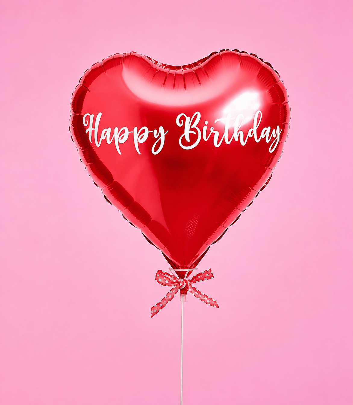 A vibrant red heart-shaped foil balloon with "Happy Birthday