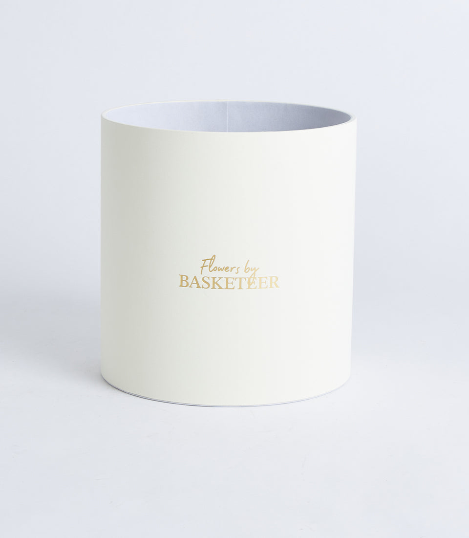Round ivory flower box with metallic gold Basketeer logo, premium gift packaging