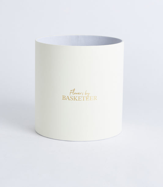 Round ivory flower box with metallic gold Basketeer logo, premium gift packaging