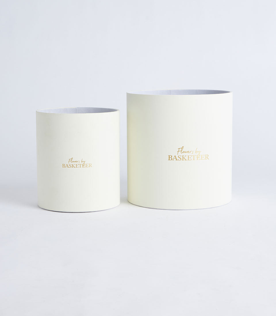 Two elegant ivory round gift boxes, one large and one small, featuring