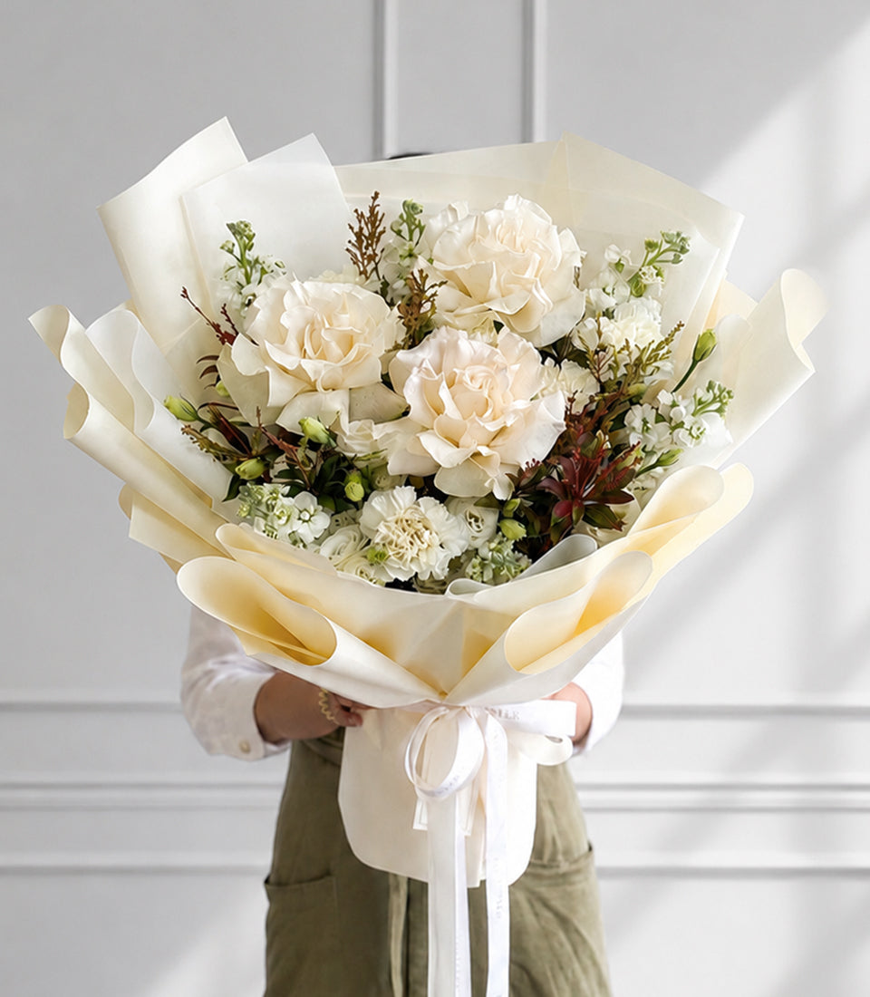 An elegant bouquet of premium creamy-white roses and delicate white filler flowers,
