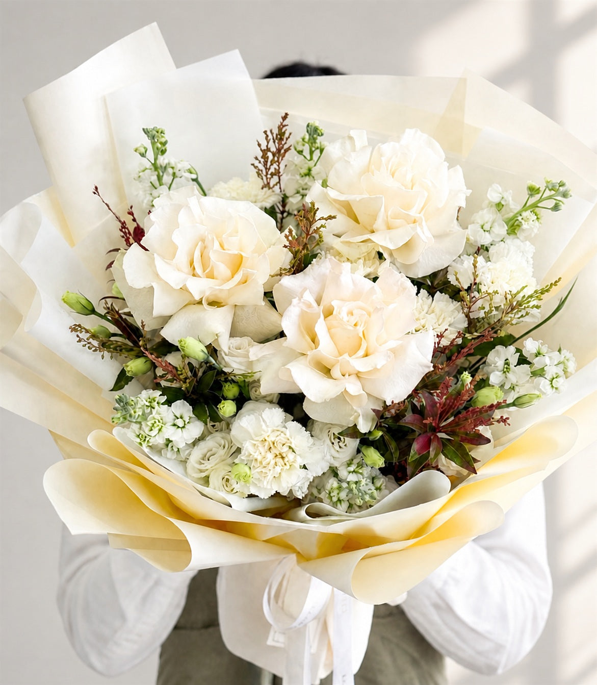 An elegant white rose bouquet with lush cream garden roses, delicate white filler flowers