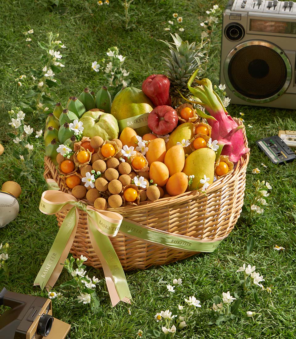 Premium Thai tropical fruit basket with papaya, mango, dragon fruit, and fresh produce in woven wicker