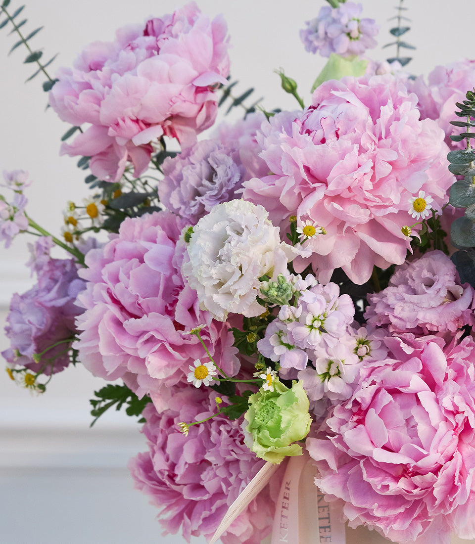 Luxurious arrangement of fluffy pink peonies, white eustoma,