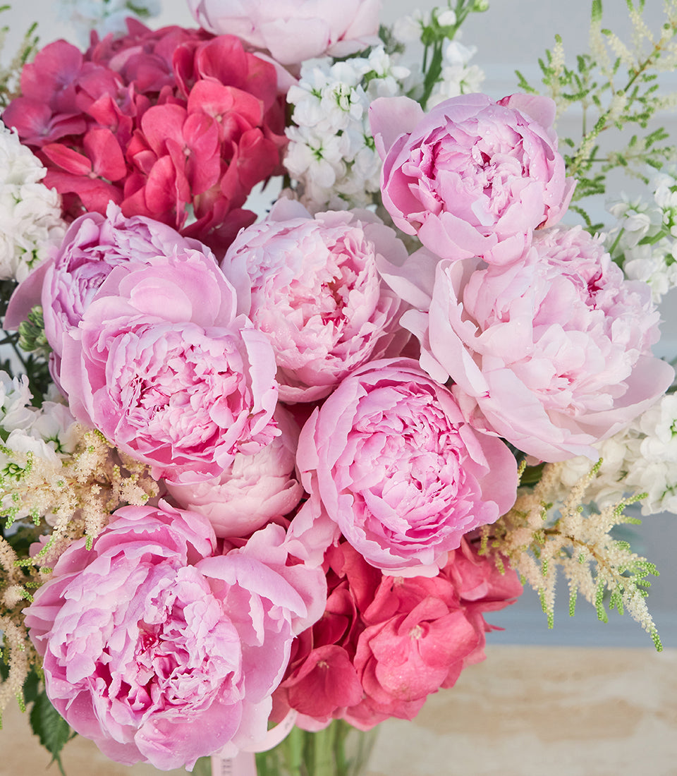 A luxurious vase arrangement from Flowers by Basketeer featuring lush pink peonies, deep