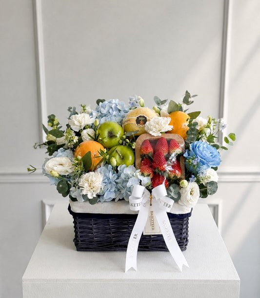 Basketeer luxury fruit and floral hamper in a dark wicker basket