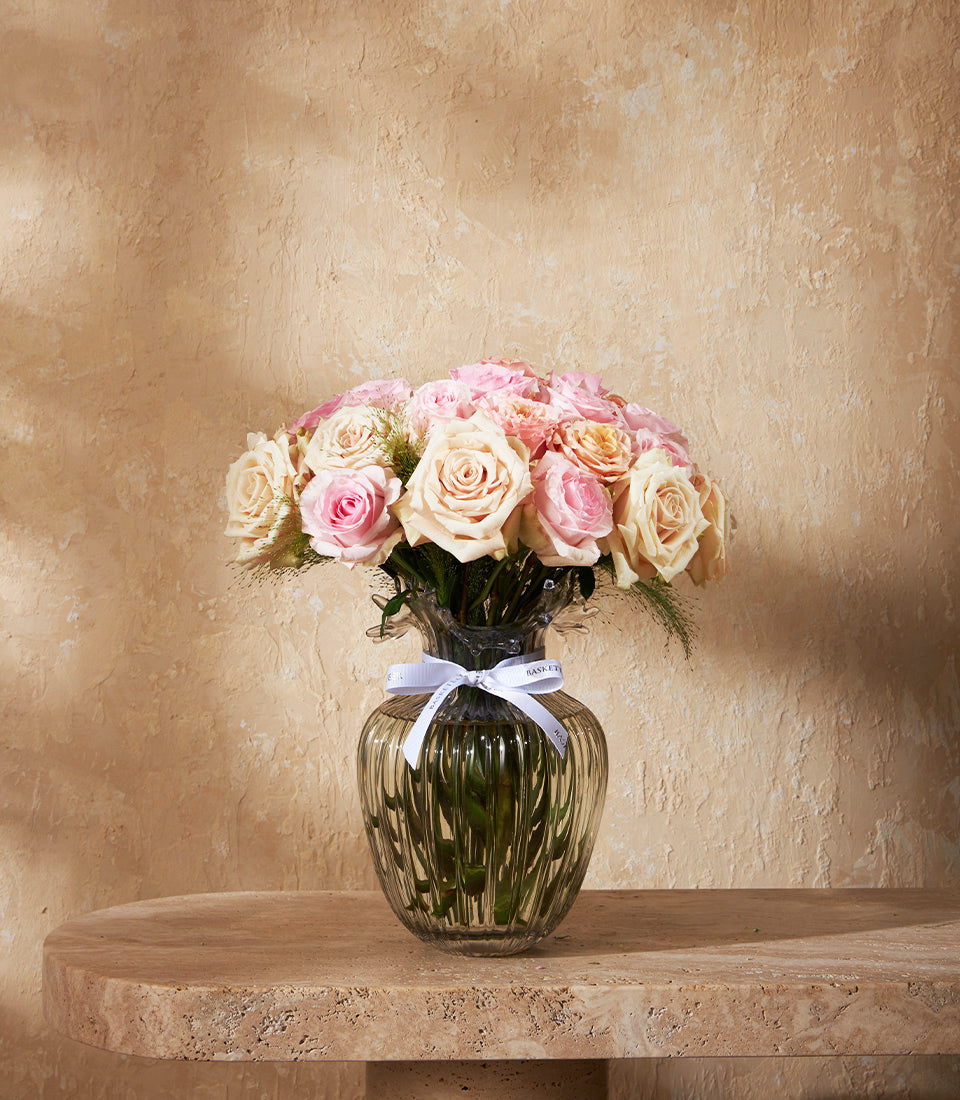 An elegant vase arrangement of premium blush pink and cream roses, delicately