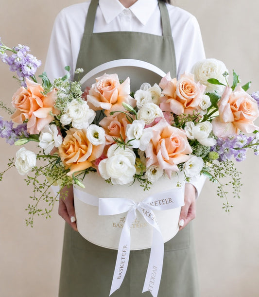 Elegant flower box arrangement from Flowers by Basketeer featuring lush peach roses
