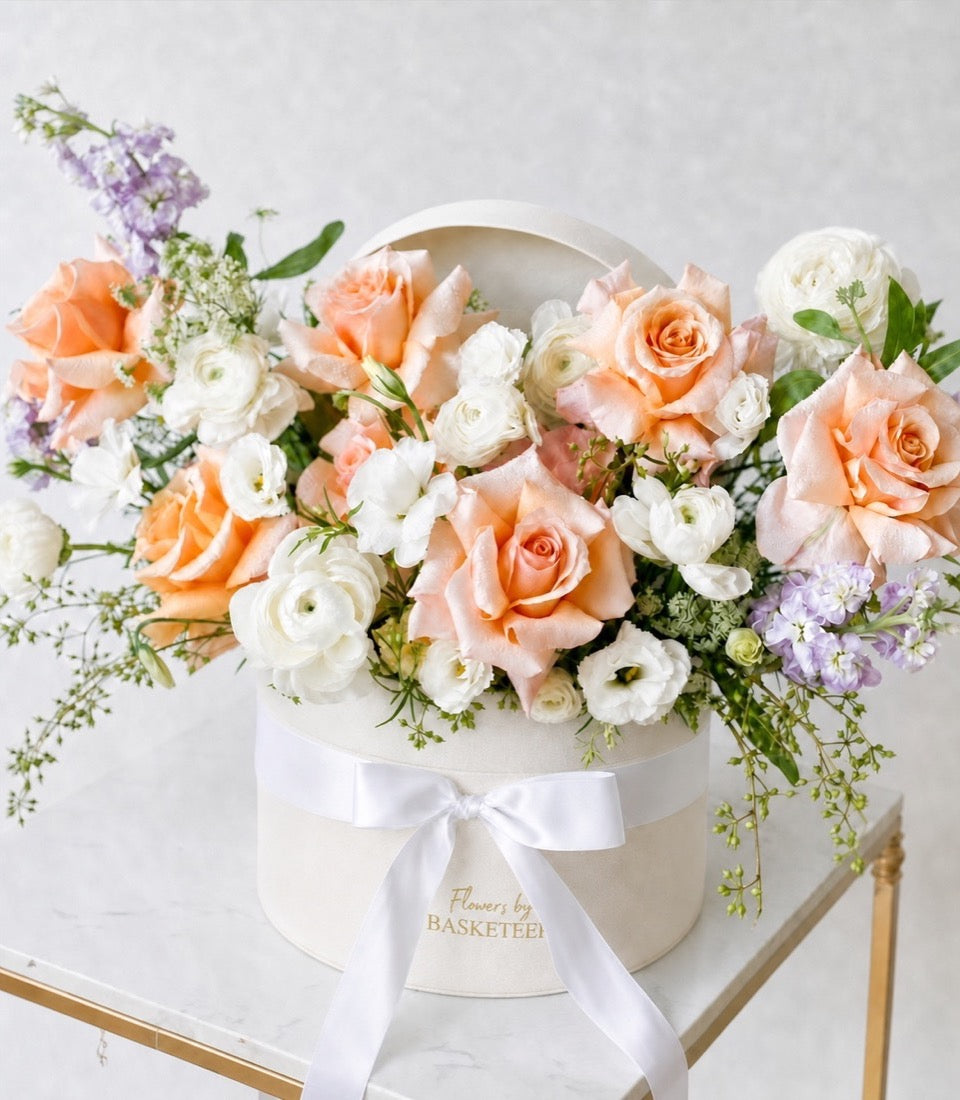 A premium flower box arrangement by Flowers by Basketeer featuring romantic peach roses, white