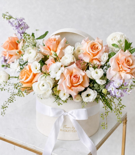 A premium flower box arrangement by Flowers by Basketeer featuring romantic peach roses, white