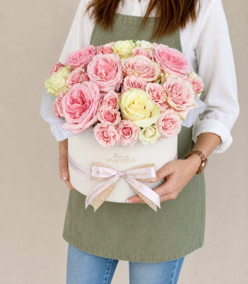 Elegant arrangement of premium pink and pale yellow roses in a luxurious cream