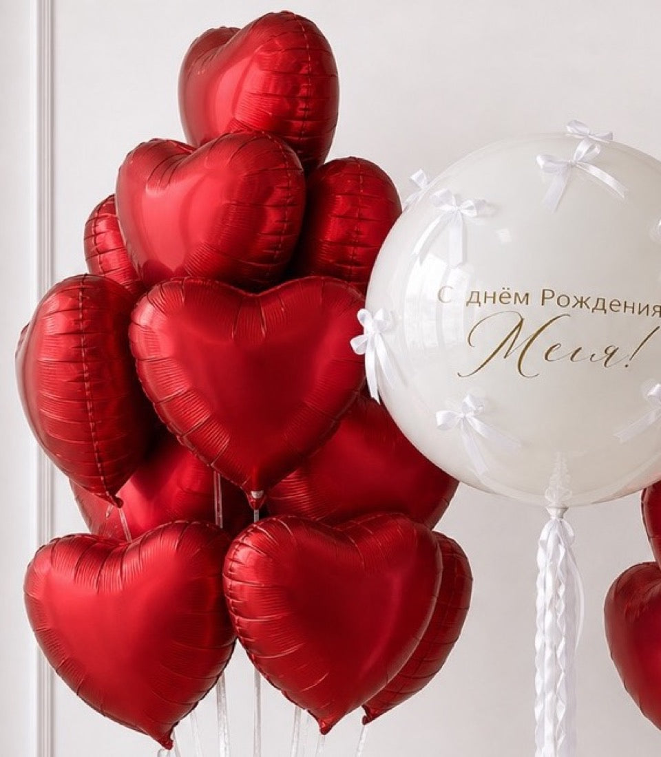 Red heart-shaped foil balloons with white pearl balloon displaying Russian birthday text, tied with ribbons.