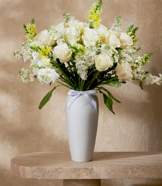 An elegant vase arrangement from Flowers by Basketeer featuring pristine white roses, stock flowers