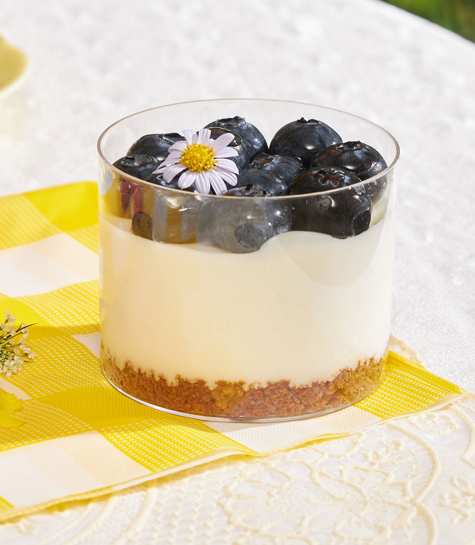 Mini Biscoff cheesecake cups with fresh blueberries and edible flower garnish in clear glass
