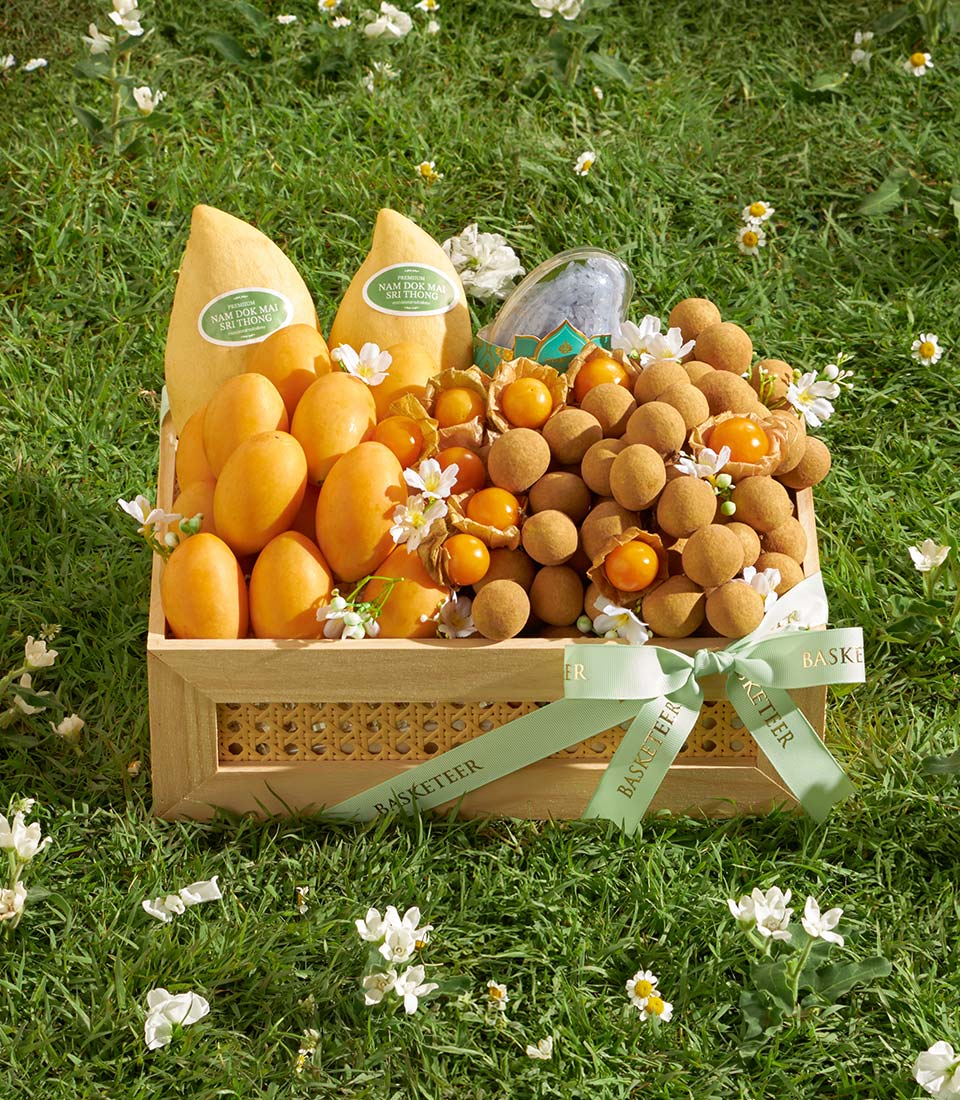 Premium wooden gift basket with Nam Dok Mai mangoes, longans, and golden berries on fresh green background
