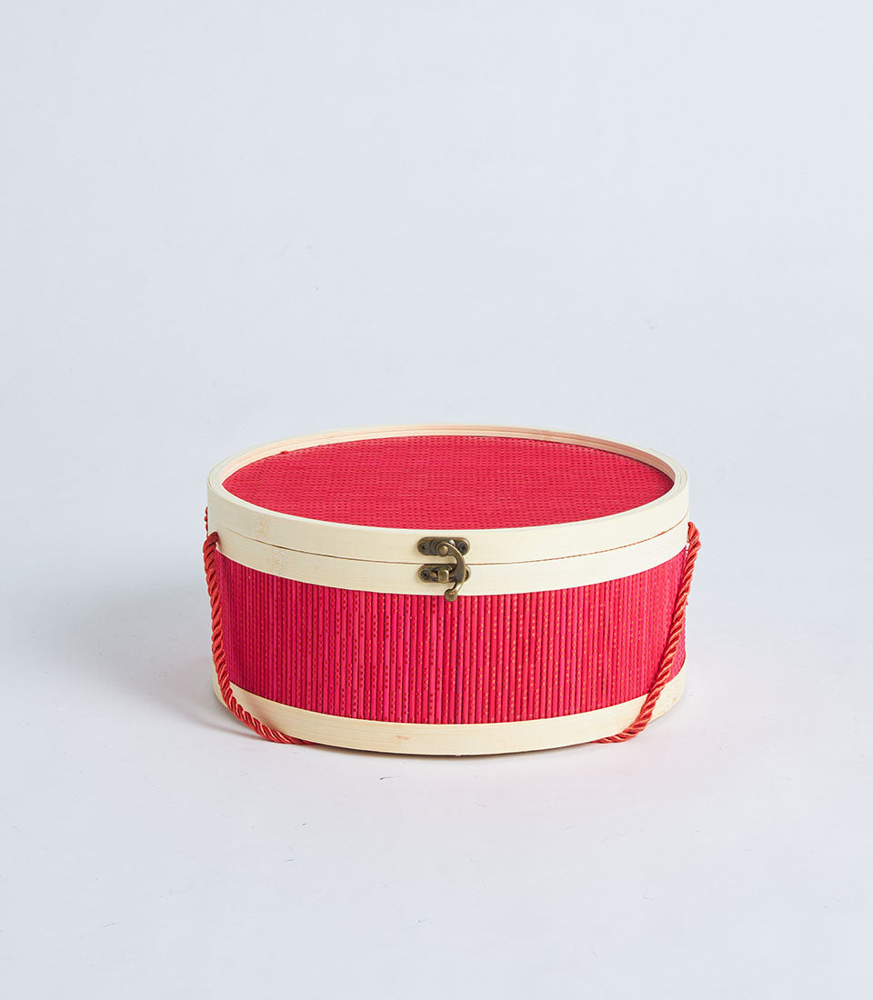 Red round gift basket with woven lid and rope handle, artisan presentation box
