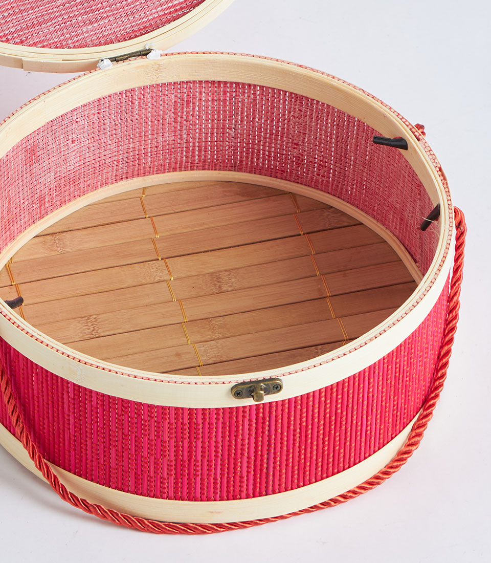 Red round woven gift basket with bamboo frame, brass latch, and rope handle for premium gifting