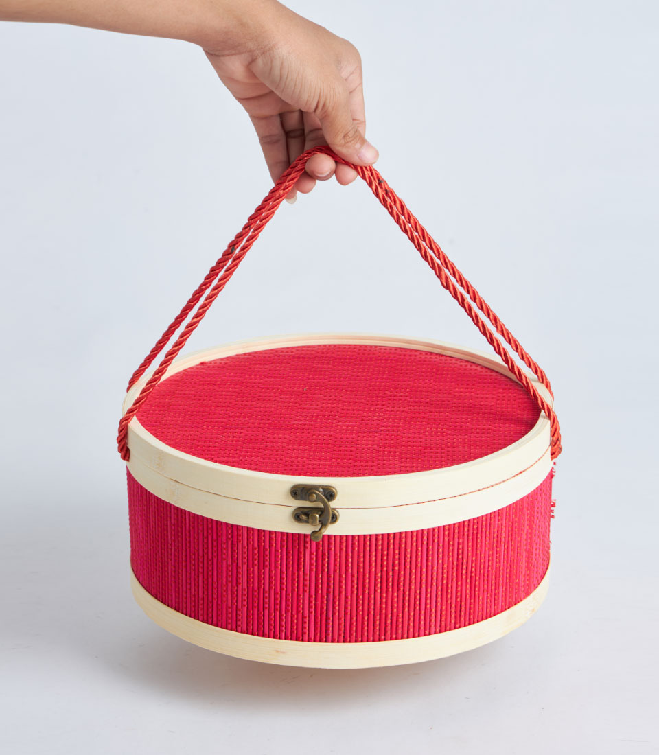 Red round bamboo gift basket with wooden frame and rope handle
