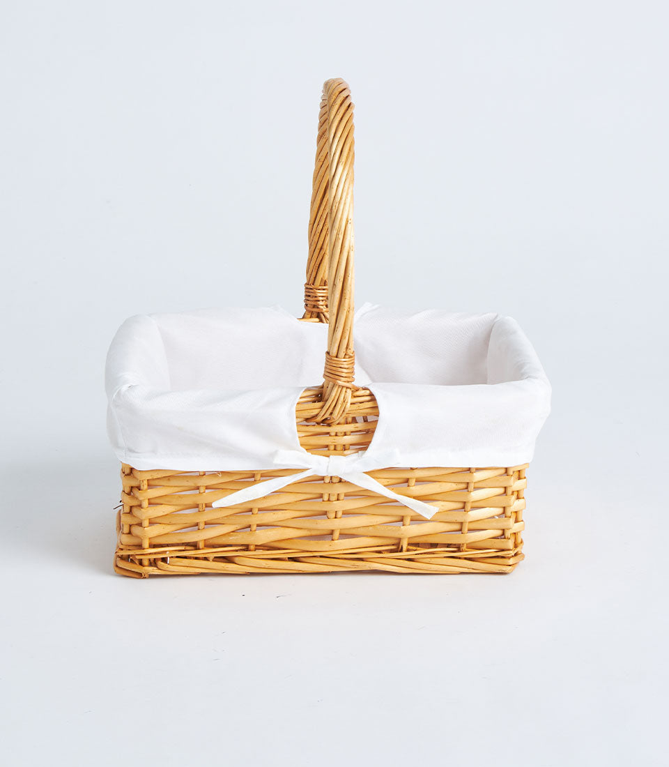Natural woven wicker basket with white fabric lining and single handle for artisan gift hampers
