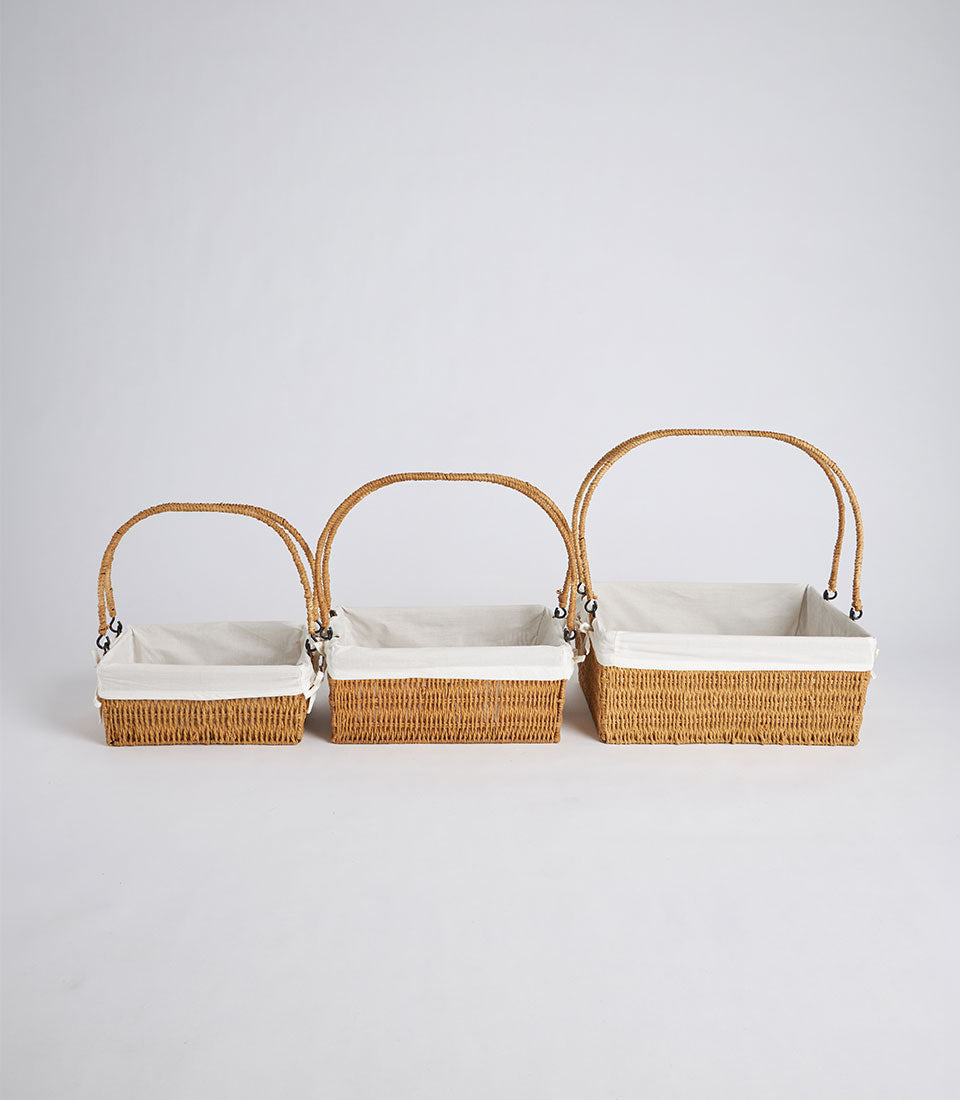 Set of three natural wicker baskets with cream linen liners and dual handles, graduated sizes